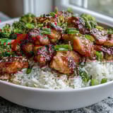 Sizzling Honey Garlic Chicken Bowl with tender glazed pieces, steamed jasmine rice, crisp stir-fried vegetables, and a sprinkle of toasted sesame seeds.