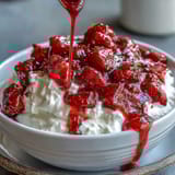 Strawberry compote swirls over creamy Greek yogurt, topped with fresh mint and honey drizzle.  