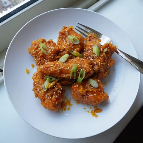 Crispy battered chicken tossed in glossy, homemade orange sauce, served over steaming jasmine rice for a classic Chinese-American takeout-style meal.