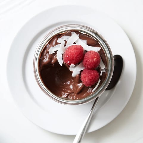 Chilled chocolate pudding in a clear glass topped with whipped cream and dark chocolate shavings.