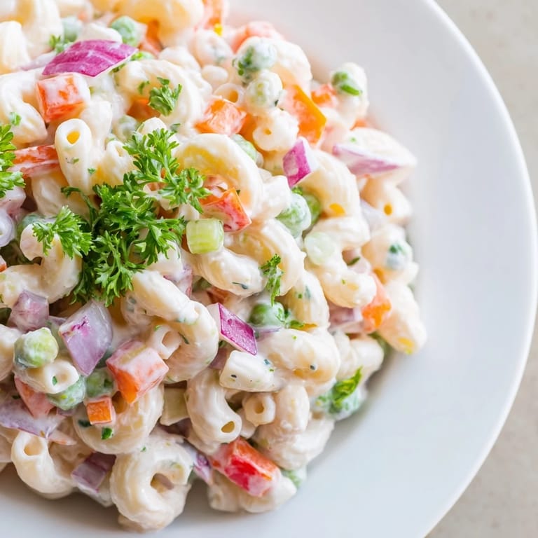 This vibrant bowl of macaroni salad showcases tender pasta with crisp veggies in a tangy dressing.