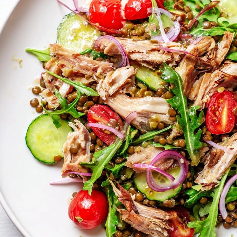 Plated Lentil & Chicken Spring Salad featuring arugula, lentils, chicken, and cherry tomatoes drizzled with a bright, tangy mustard dressing.