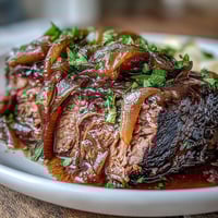 Savory Crock Pot French Onion Pot Roast simmered in a slow cooker, topped with gooey melted Gruyère and fresh parsley.